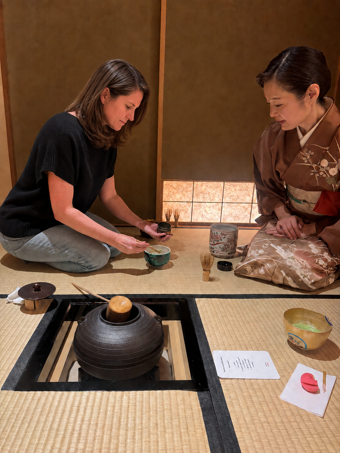 Kirsty Dunphey preparing matcha in a traditional Japanese tea ceremony with a kimono-clad tea master in a tatami tea room